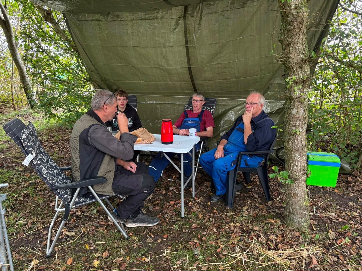 Frivillige holder pause og får en snak under teltdugen